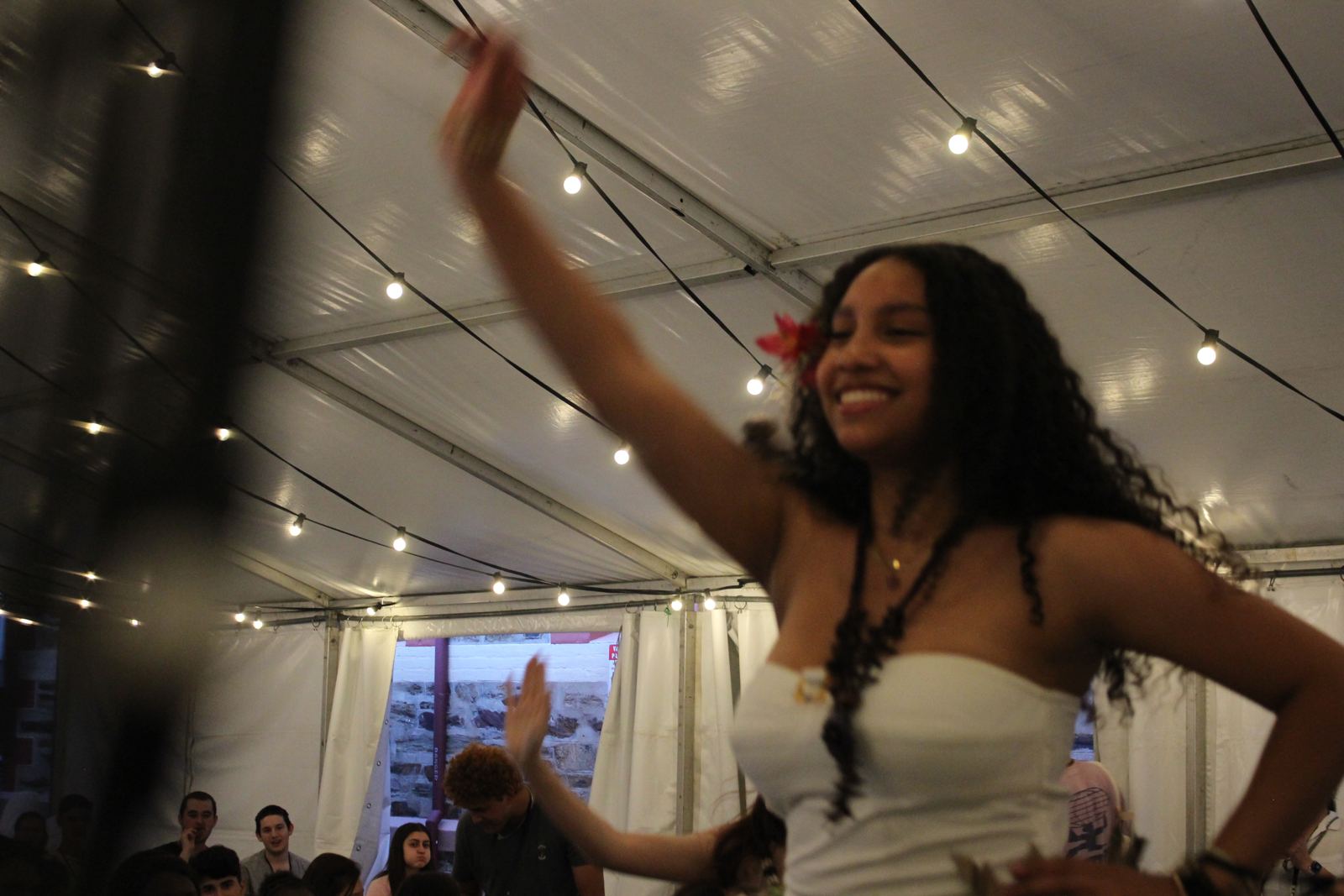 A dancer smiling under the marquee fairy lights