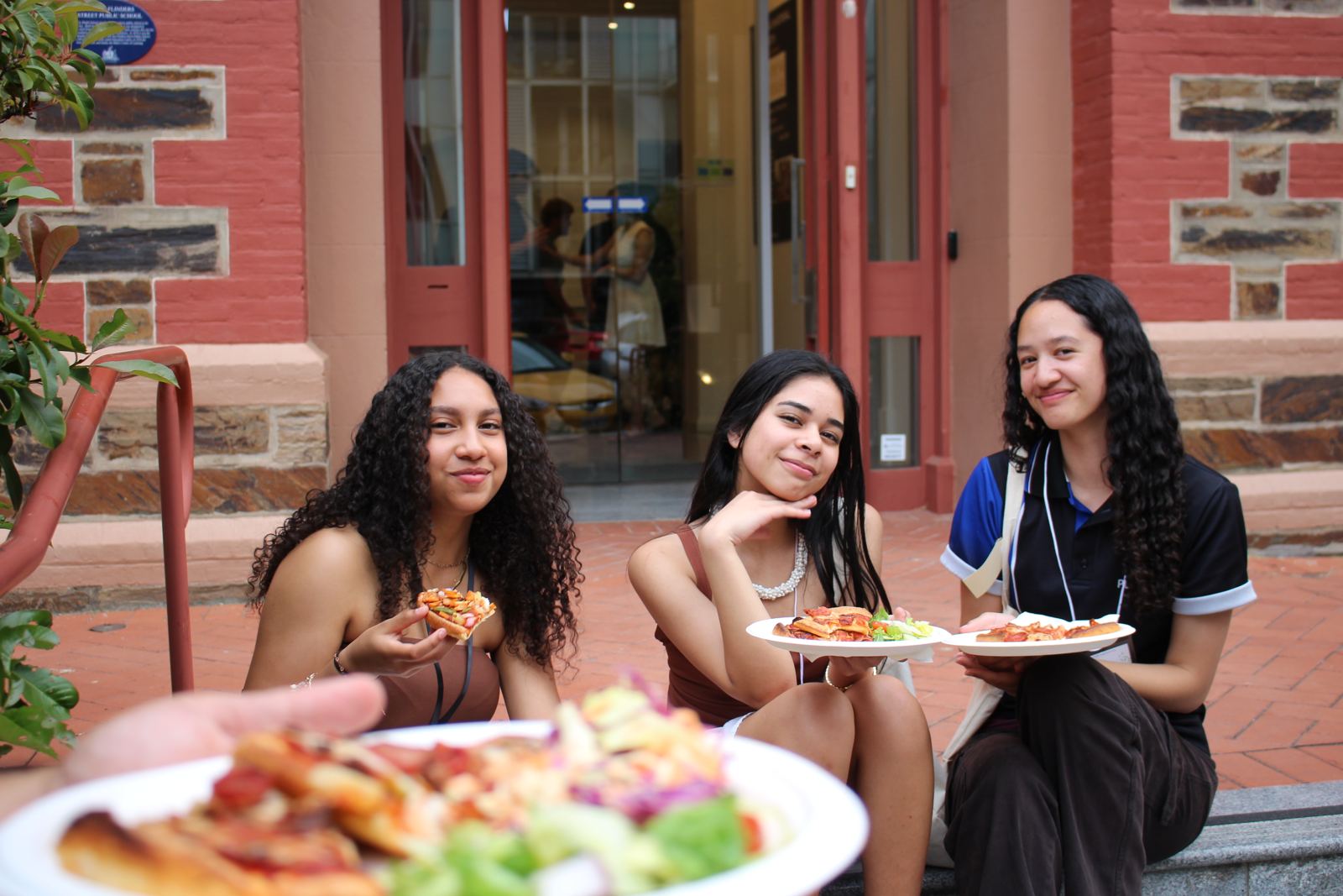 Friends eating dinner on the steps outside